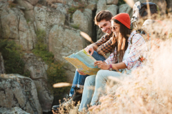 graphicstock-side-view-of-adventure-couple-with-map-sitting-on-slope-near-the-canyon_Bu_7wBL3x.jpg